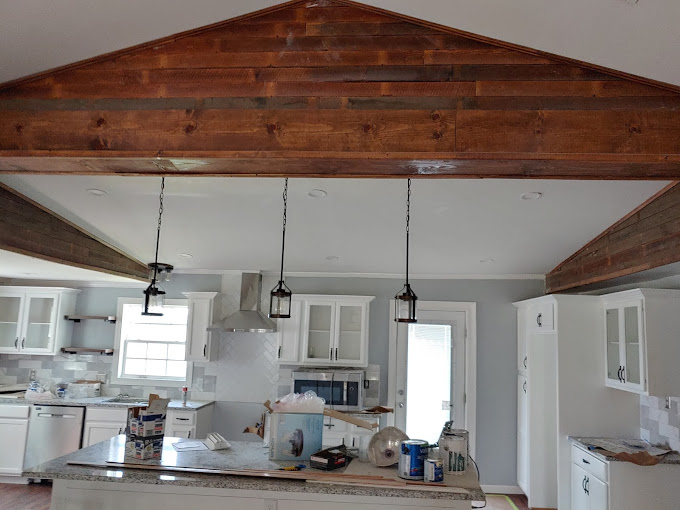 A kitchen with a wooden ceiling and white cabinets