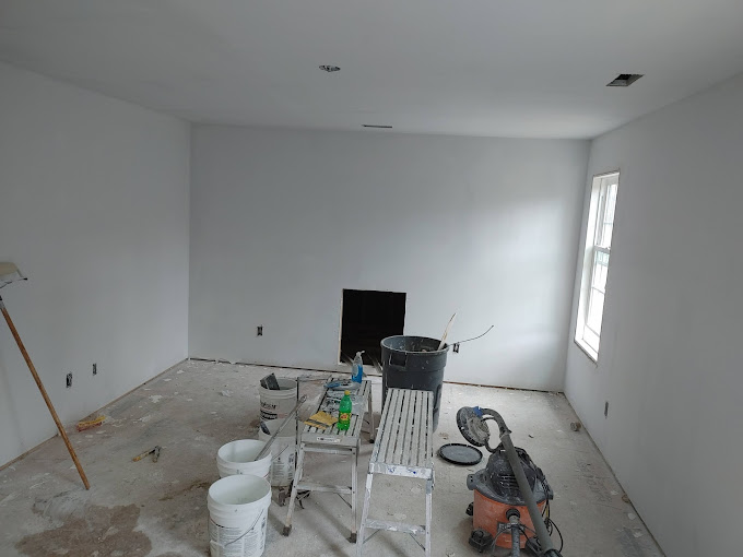 A room with a ladder and buckets of paint