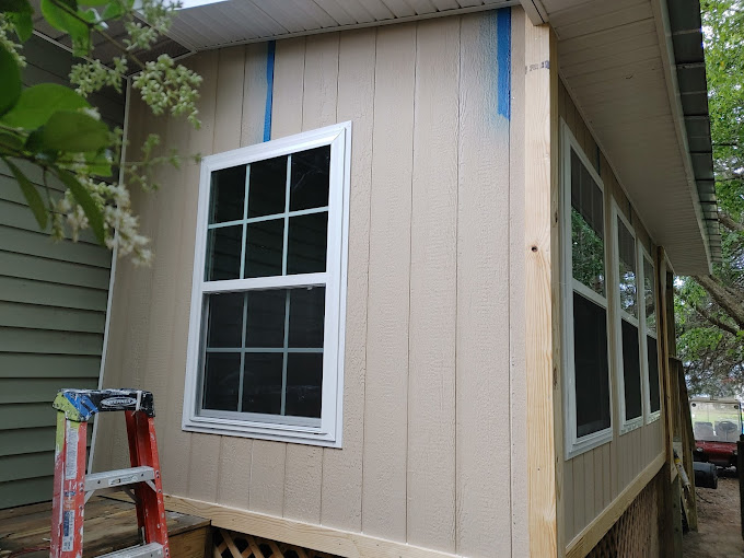 A house being built with a ladder and windows