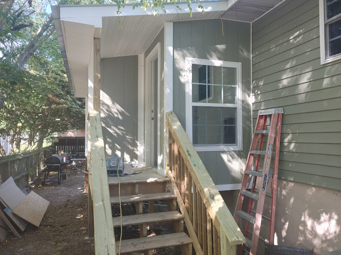 A small house with a porch and stairs